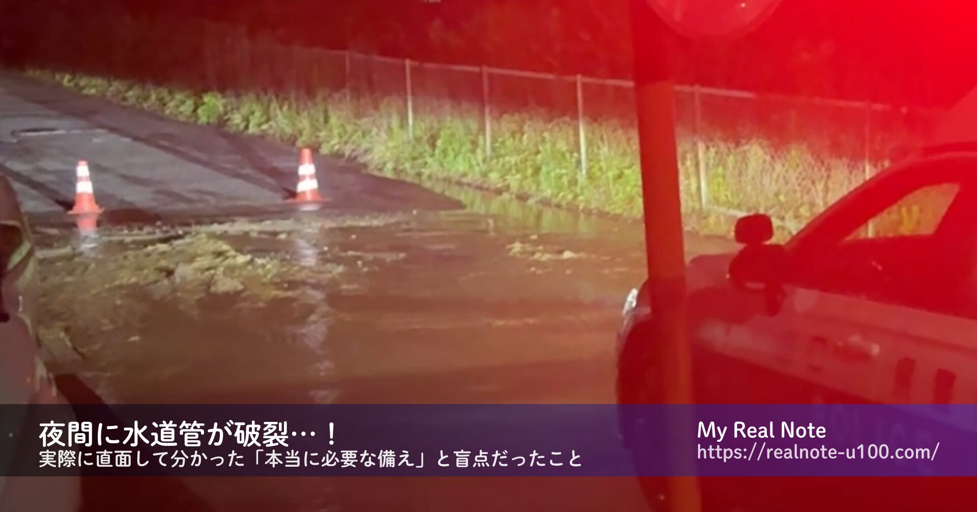 夜間に水道管が破裂して道路から水があふれだす様子